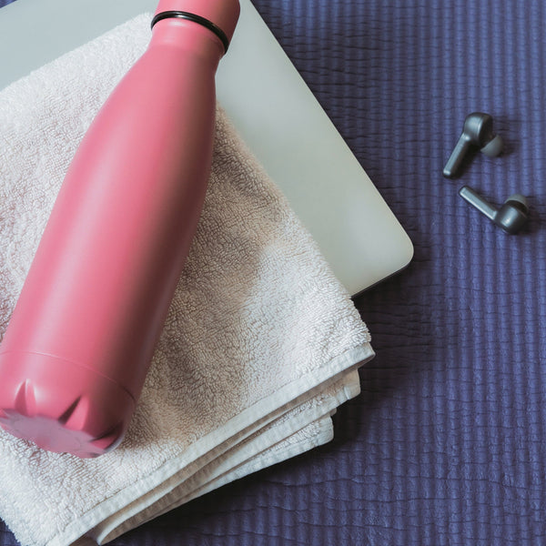 un matelas / tapis de sport avec gourde et écouteurs pour faire du coaching sportif à Lyon à domicle ou en salle à caluire et cuire